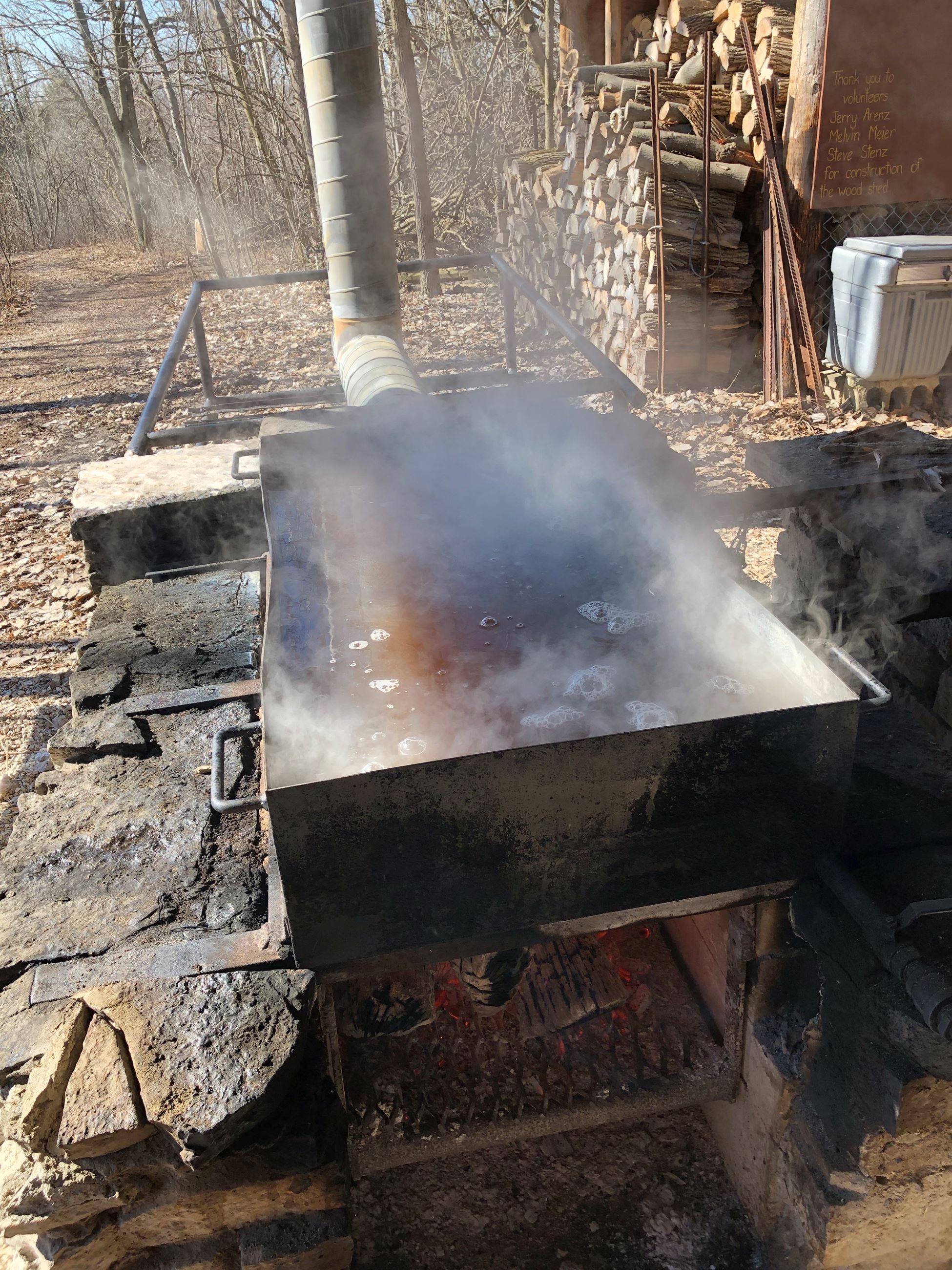 A large rectangular pan of boiling maple syrup. 